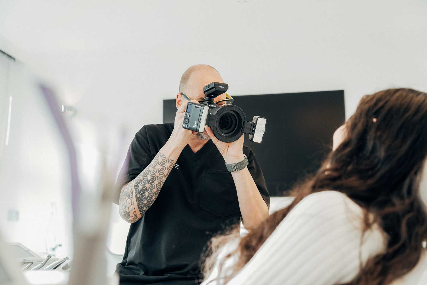 Ein Zahntechniker von NOVA–Z fotografiert den Mund einer Patientin