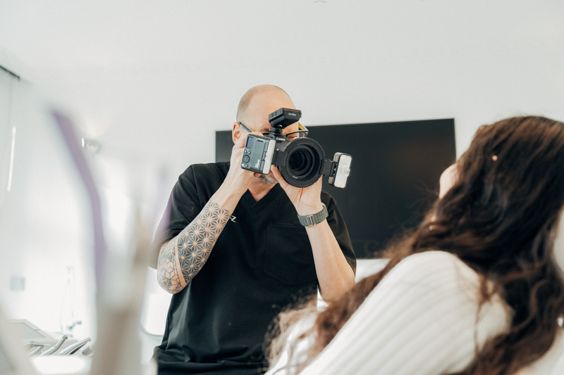 Ein Zahntechniker von NOVA-Z fotografiert den Mund einer Patientin
