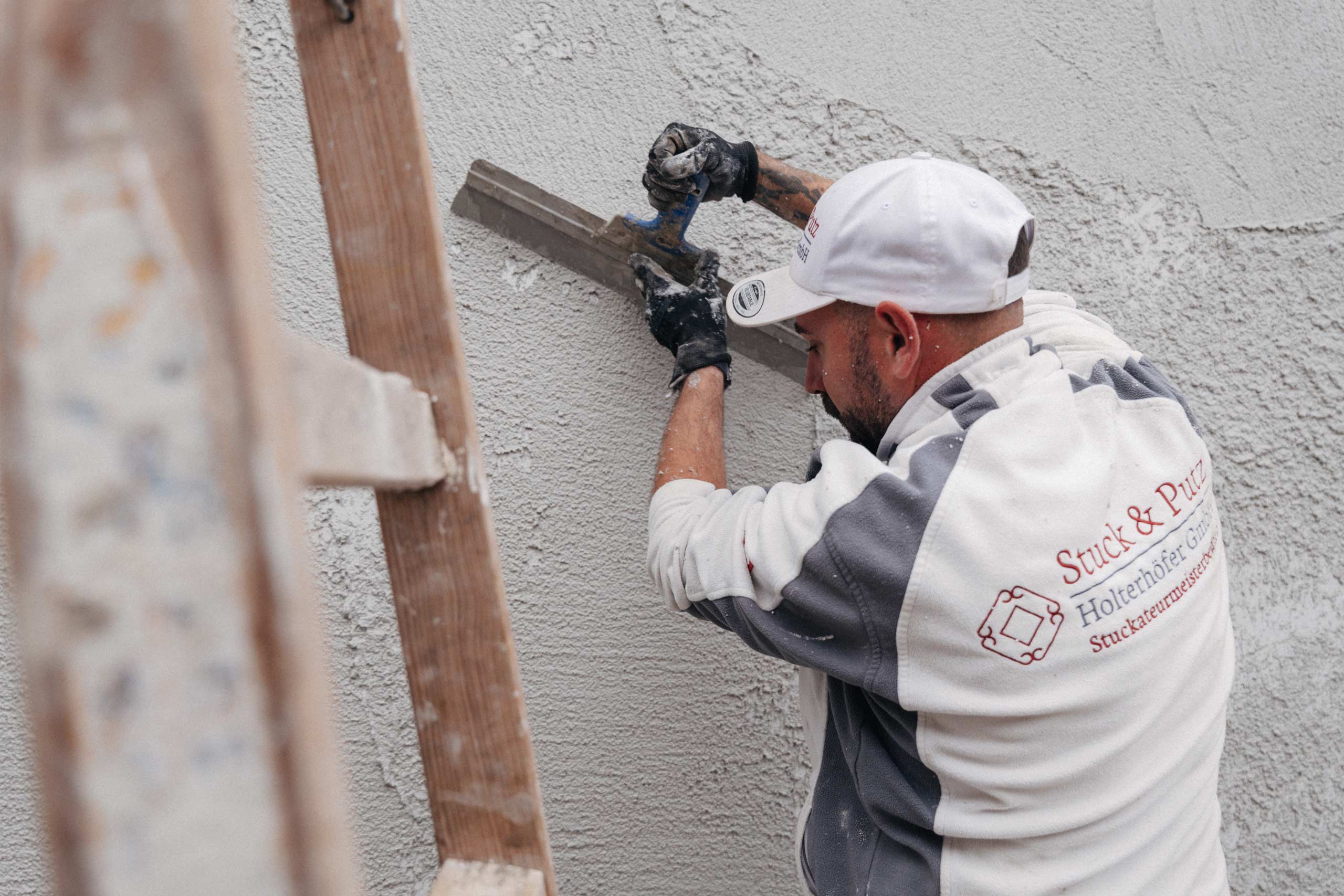 Stuckateurmeister Sven Holterhöfer verputzt eine Außenfassade