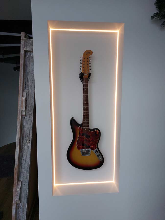 Referenzprojekt: Eine Gitarre hängt in einem extra dafür in die Wand eingelassenen Rahmen