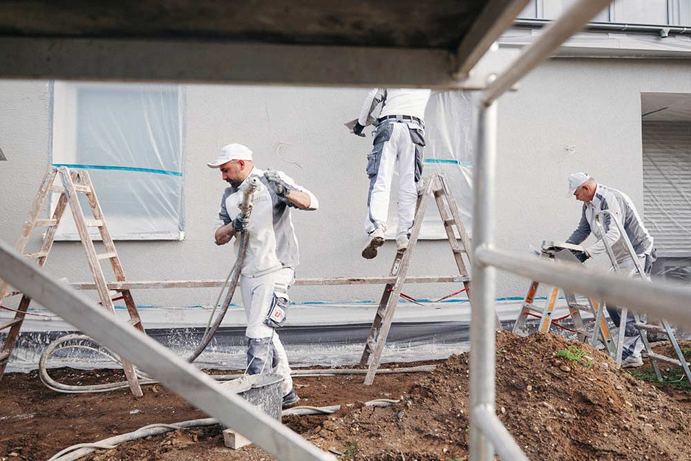 Team von Stuck & Putz beim Verputzen einer Außenfassade
